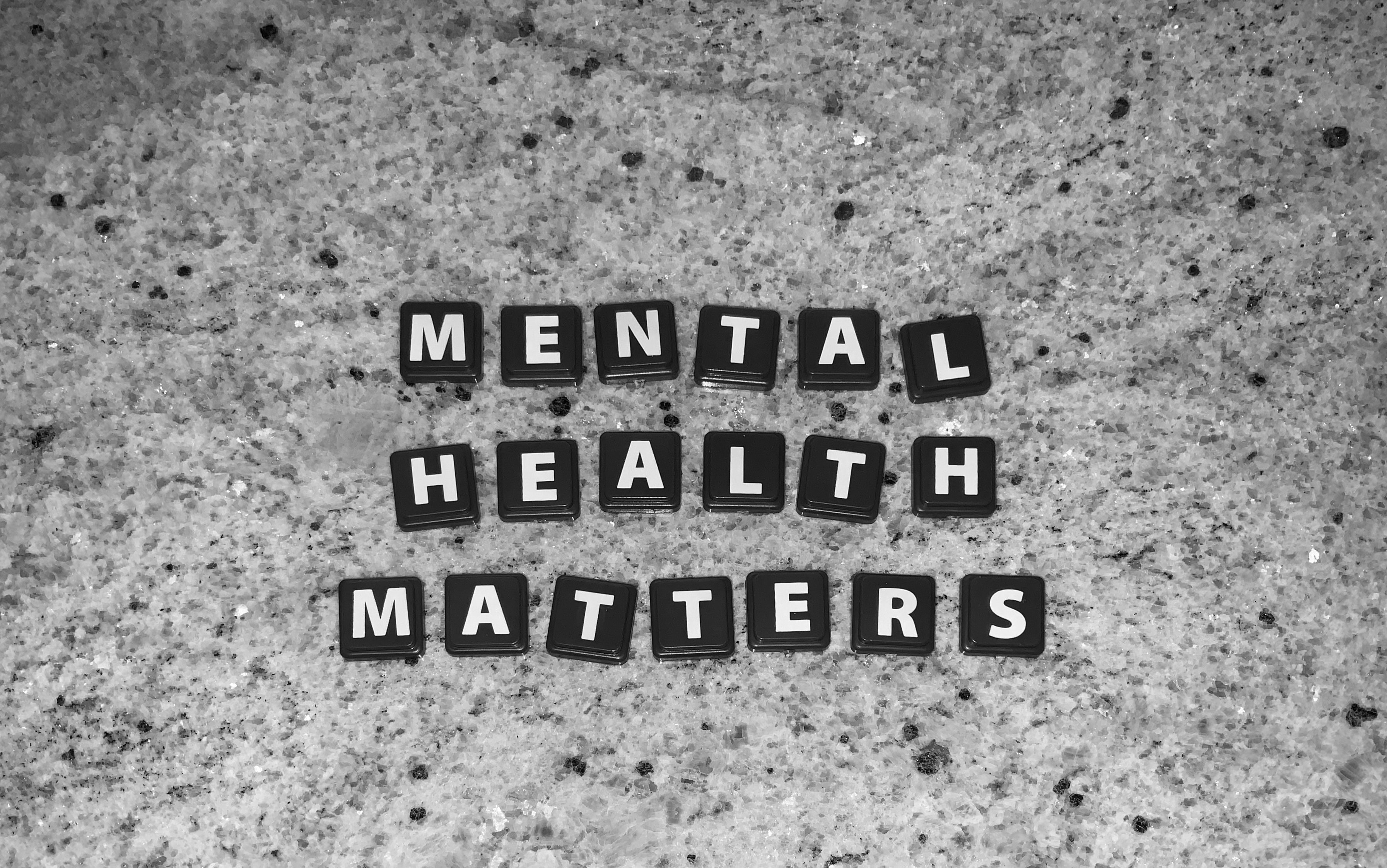 Squares spelling out mental health matters on a grey background